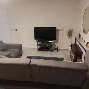 a living room with a couch and a flat screen tv at Lovely & Beautiful 2 Bed-Apartment in Borehamwood in Borehamwood