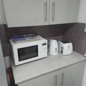 a kitchen counter with a microwave and toasters on it at Lovely & Beautiful 2 Bed-Apartment in Borehamwood in Borehamwood