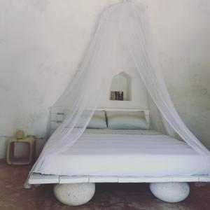 een wit bed met een baldakijn in een kamer bij Trullo Mareposa in Sannicola