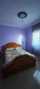 1 dormitorio con 1 cama en una habitación púrpura en Mini villa, en Saidia 