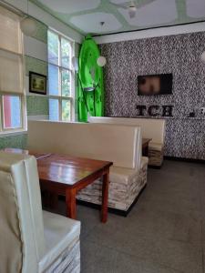 una sala da pranzo con tavolo e sedia verde di The Coastal Hotel a Trincomalee