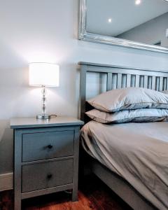 a bedroom with a bed and a nightstand with a lamp at Private Room in Lucan