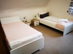 2 Betten in einem Zimmer mit 2 Tischen in der Unterkunft FeWo Haus Emma OG in Löhnberg