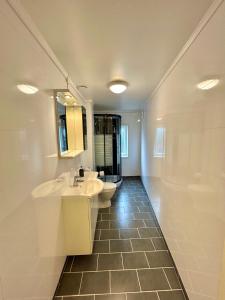 a bathroom with two sinks and a toilet and a mirror at Gjestehuset Borggata 18 in Fredrikstad