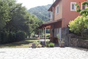 una casa con una entrada de piedra delante de ella en Ξενώνας ΙΙ σε αγροικία με τζακι, en Kalavrita
