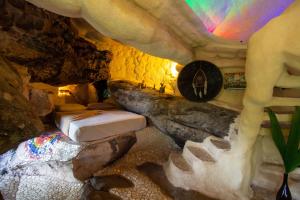 um quarto numa caverna com uma cama numa parede de pedra em Pousada Flor de Açucena em Igatu