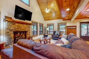 a living room with a couch and a stone fireplace at Roosters Roost in Blue Ridge