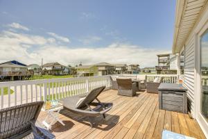 a deck with chairs and a grill on a house at Walk to Beach Updated Home with Deck in Galveston! in Galveston