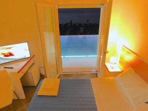 ローディ・ガルガーニコにあるAlbergo Lido Diomedeeのベッド1台付きの部屋、窓付きのドア