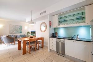 a kitchen with a table and a dining room at Poolside luxury on Hastings St 212 in Noosa Heads