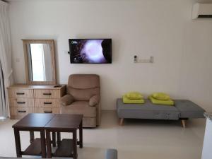 ein Wohnzimmer mit einem Sofa, einem Stuhl und einem Tisch in der Unterkunft هوانا صلاله in Ma‘mūrah