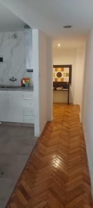 cocina con armarios blancos y suelo de madera en Departamento Pucara Obelisco en Buenos Aires