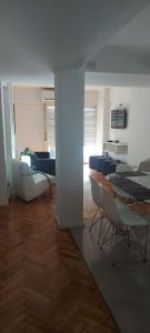 Habitación con mesas, sillas y sala de estar. en Departamento Pucara Obelisco en Buenos Aires