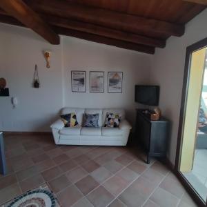 uma sala de estar com um sofá e uma televisão em Casa Maya em Valledoria