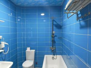 a blue tiled bathroom with a toilet and a sink at Hotel Lilo near Airport in Tbilisi City