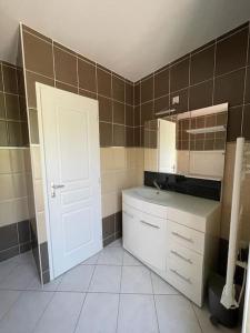 a bathroom with a white door and a sink at maison lumineuse in Villemoustaussou