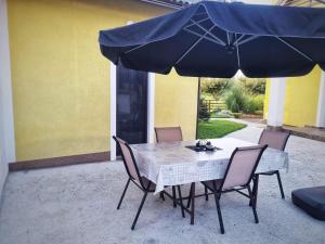 einen Tisch und Stühle unter einem blauen Schirm in der Unterkunft Soba - Room - Zimmer M in Karlovac