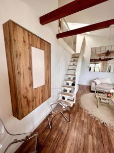 a living room with a wooden wall and a staircase at BALI HOME Stylische Wohnung mit Terrasse in Schönefeld