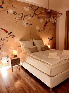 a bedroom with a white bed with flowers on the wall at BALI HOME Stylische Wohnung mit Terrasse in Schönefeld