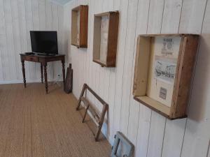 una stanza con una televisione e una scrivania con una televisione di LA TERRASSE AUX HIRONDELLES maison 80m2 2 chambres 2 salles de bains a Lagorce