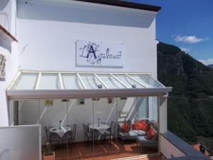 a restaurant with chairs and a sign on the side of a building at L'Arabesco B&B in Amalfi