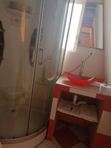 uma casa de banho com um chuveiro e um lavatório vermelho em BUNGALOWS YAHUARCOCHA em Ibarra