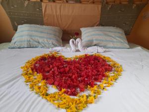 un corazón hecho de flores en una cama en BUNGALOWS YAHUARCOCHA, en Ibarra