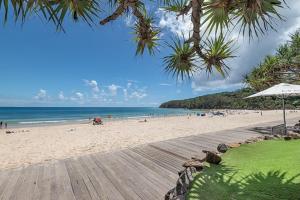 a beach with a wooden boardwalk and the ocean at Luxury in the Heart of Hastings street 628 in Noosa Heads