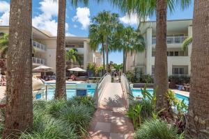 a resort pool with a slide and palm trees at Luxury in the Heart of Hastings street 628 in Noosa Heads