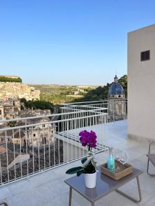 a table with a flower on top of a balcony at La casa di Irene - Suites con vista in Ragusa