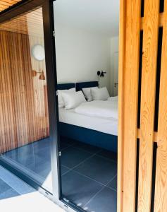 1 dormitorio con 1 cama a través de una puerta de cristal en Route du Circuit 23 en Stavelot