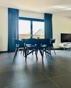 a dining room with a table and chairs and a couch at Route du Circuit 23 in Stavelot