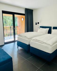 2 camas en una habitación de hotel con balcón en Route du Circuit 23 en Stavelot
