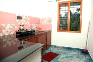 a kitchen with a counter top and a window at Golden cherry in Munnar