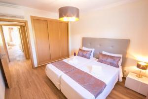 Un dormitorio con una gran cama blanca en una habitación. en Marina Garden Apartment, en Albufeira 16 fotos más