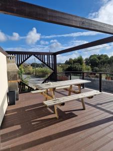 una mesa de picnic en una terraza con un puente en Atlantic Spot Guest House en Praia de Mira