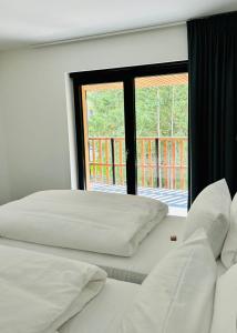 two beds in a room with a large window at Route du Circuit 23 in Stavelot