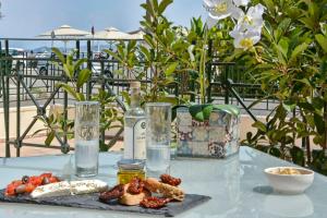 een tafel met een bord eten en een fles wijn bij Corfu Town Luxury Studios -A in Corfu-stad