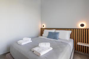ein Schlafzimmer mit einem Bett mit Handtüchern darauf in der Unterkunft SUMMER PEARLS LUXURY VILLAS in Polychrono