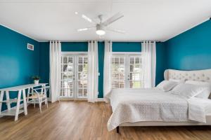 a bedroom with blue walls and a bed and a table at Ultimate Waterfront Oasis Heated Pool & Boat Dock in Tampa