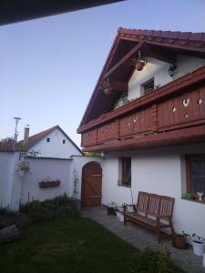 ein weißes Haus mit einer Bank im Hof in der Unterkunft Relax in Zlatá Koruna