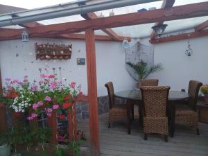 eine Terrasse mit einem Tisch, Stühlen und Blumen in der Unterkunft Relax in Zlatá Koruna