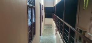 un pasillo con una escalera con paneles de cristal en las paredes en Hallima Service Apartments Non Ac Homestay low Budget, en Pudukkottai