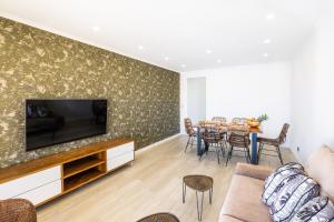 a living room with a television and a table with chairs at Benjamin Apartment in Guia