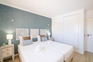 1 Schlafzimmer mit 2 weißen Betten und einer grünen Wand in der Unterkunft Benjamin Apartment in Guia + 12 Fotos
