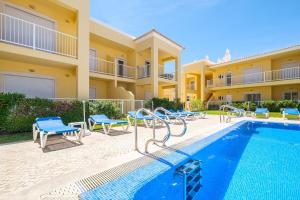 Villa con piscina y sillas azules en Benjamin Apartment, en Guia