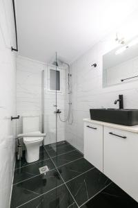 La salle de bains blanche est pourvue d'un lavabo et de toilettes. dans l'établissement Siesta Apartment, à Kalamata