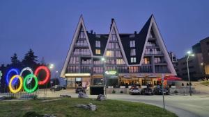 a large building with a sign in front of it at Apartman "AROMA 1"Bjelasnica in Bjelašnica