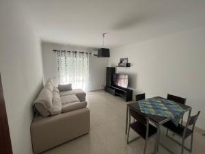 ein Wohnzimmer mit einem Sofa und einem Tisch in der Unterkunft Rosas no Lagar in Vila Nova De Cacela