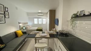 una pequeña sala de estar con mesa y sofá en Loft en Las Canteras, en Las Palmas de Gran Canaria